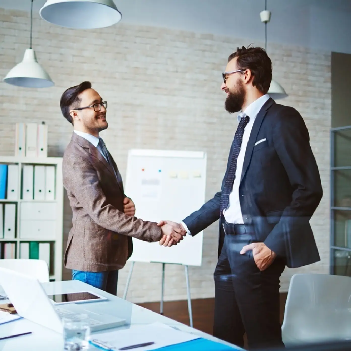 Two businessmen shaking hands in office.
